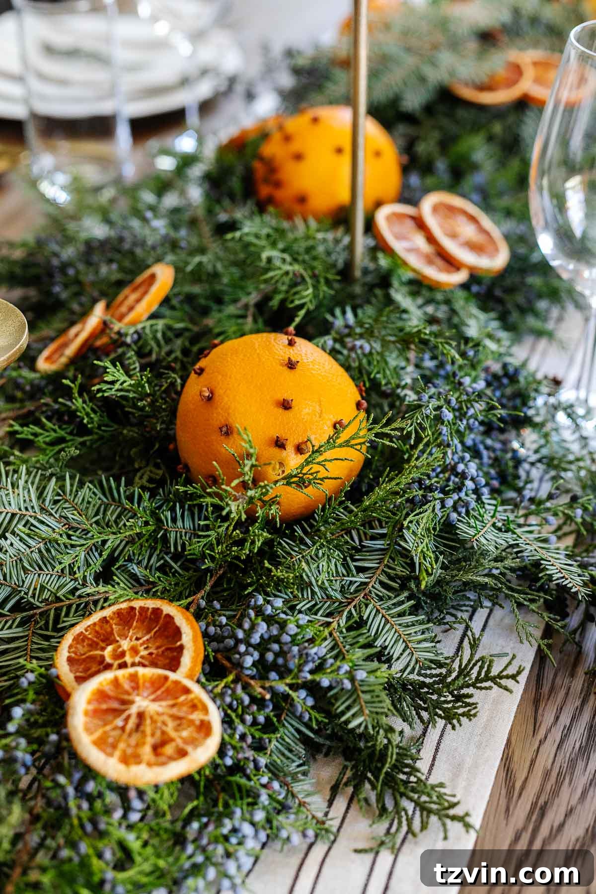 Striking orange and blue juniper berry Christmas dining table centerpiece with natural elements
