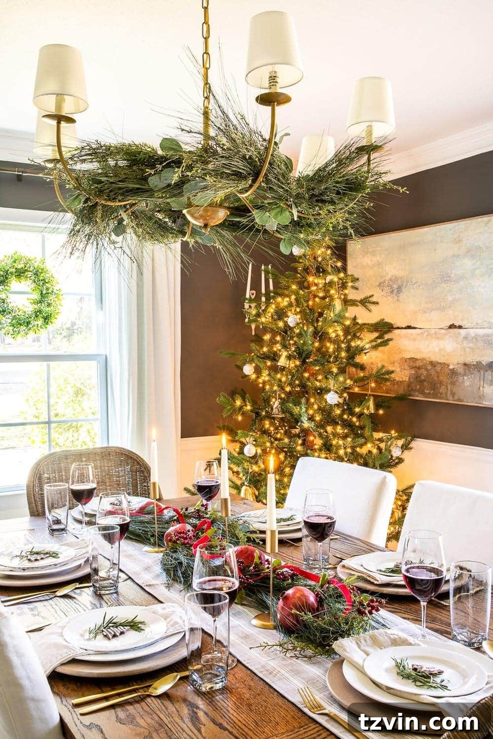 Elegant Christmas chandelier decor adorned with evergreen branches, creating a dramatic focal point