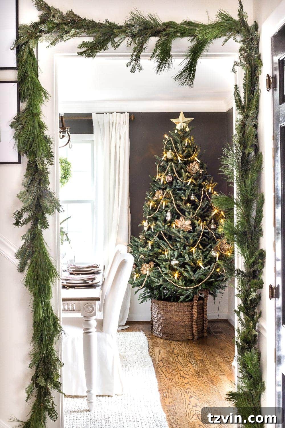 Fresh Christmas garland beautifully displayed around a doorway with a real Christmas tree nearby, creating a welcoming entrance