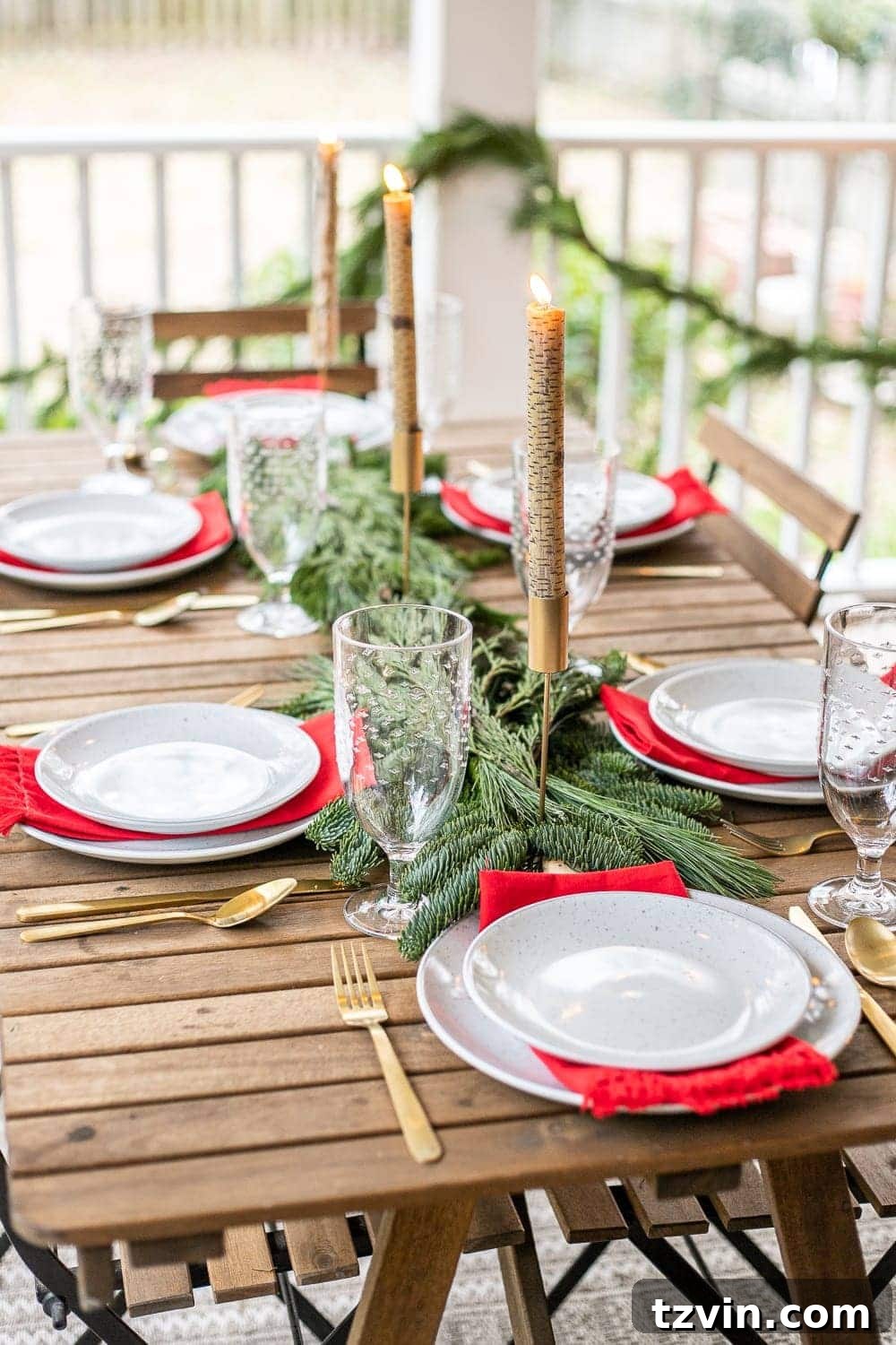 Lush evergreen table runner made from pine branches, adorned with candles for a cozy Christmas dining setting