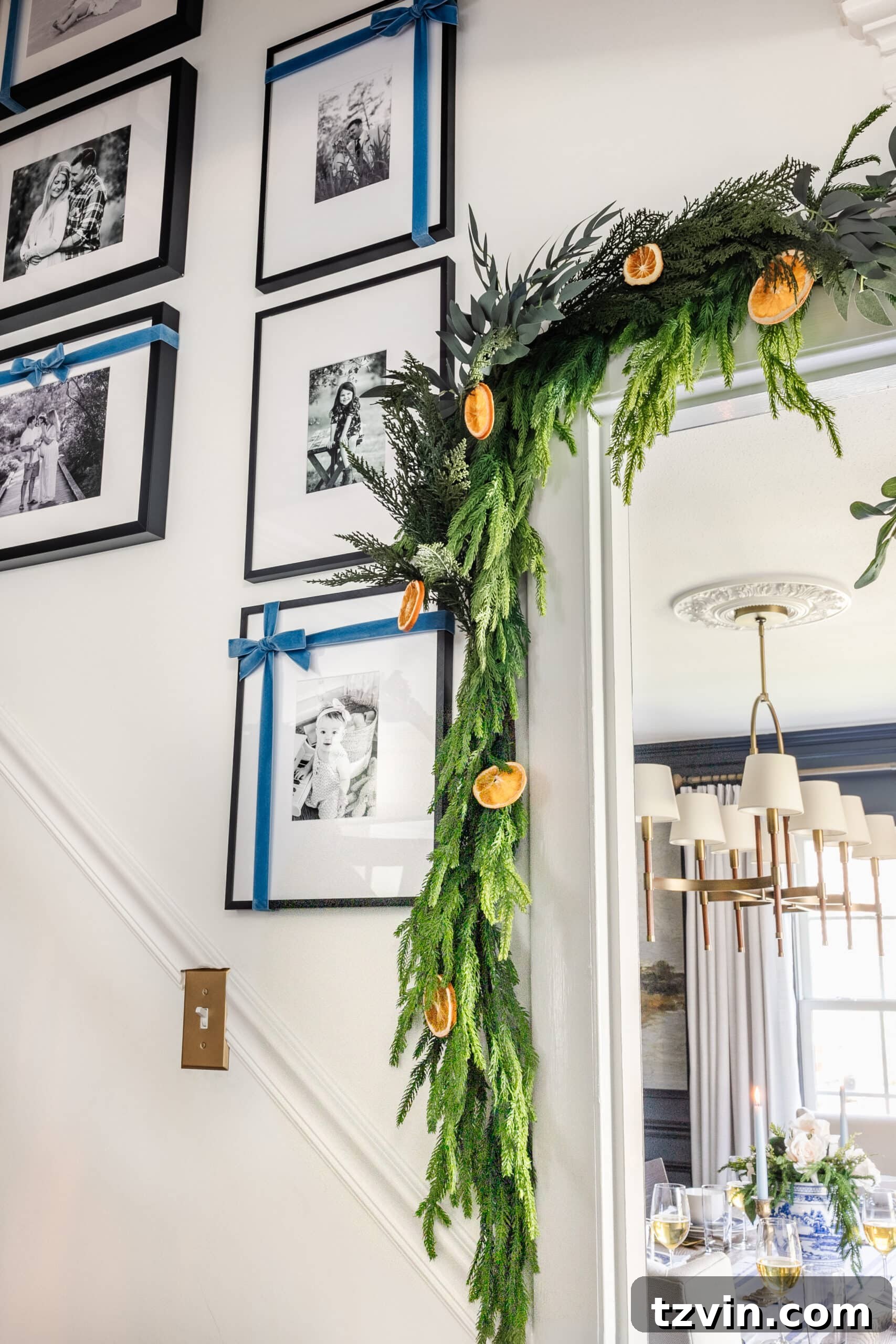 Elevate Your Faux Garland: Secrets to Unbelievable Realism 10 garland around a doorway with dried orange slices and blue ribbon, creating a festive look