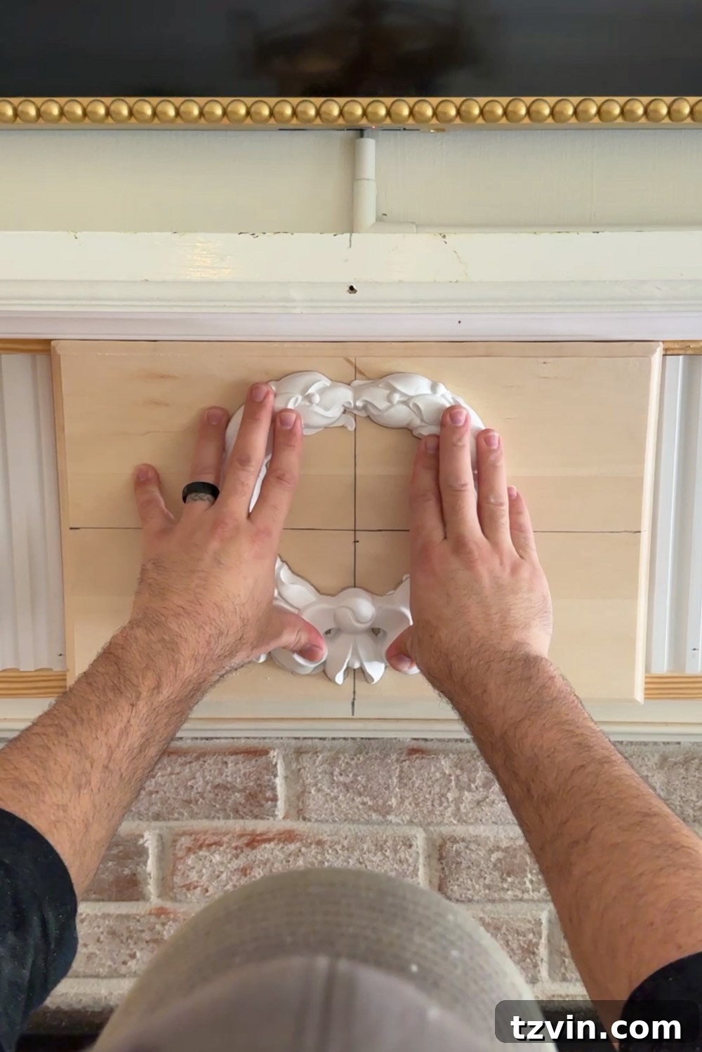 Classic Style DIY Fireplace Molding Transformation 19 Attaching wreath overlay with construction adhesive to fireplace