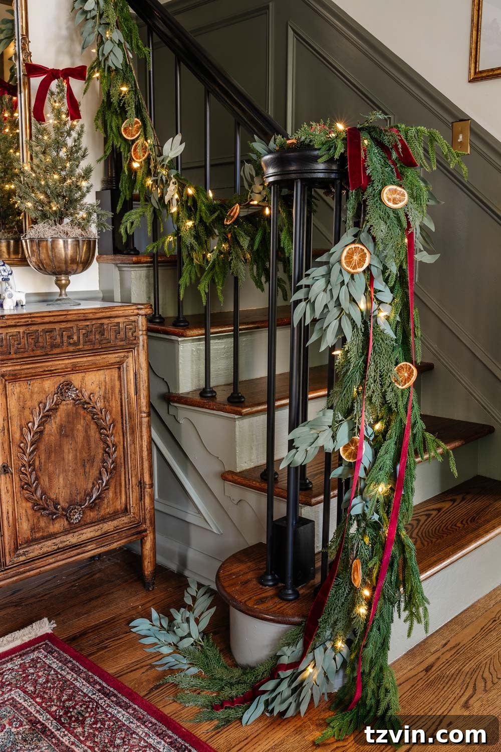 staircase railing garland with dried orange slices and red ribbon