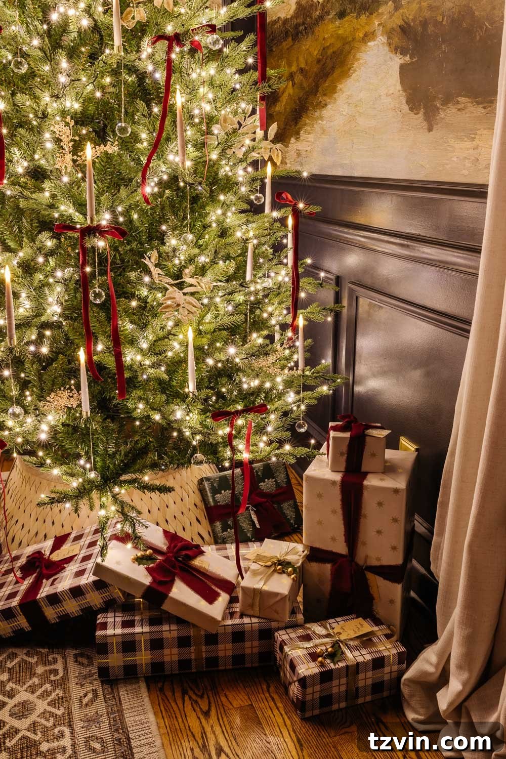Festively wrapped gifts nestled under a glowing Christmas tree at night, illuminated by soft candlelight.