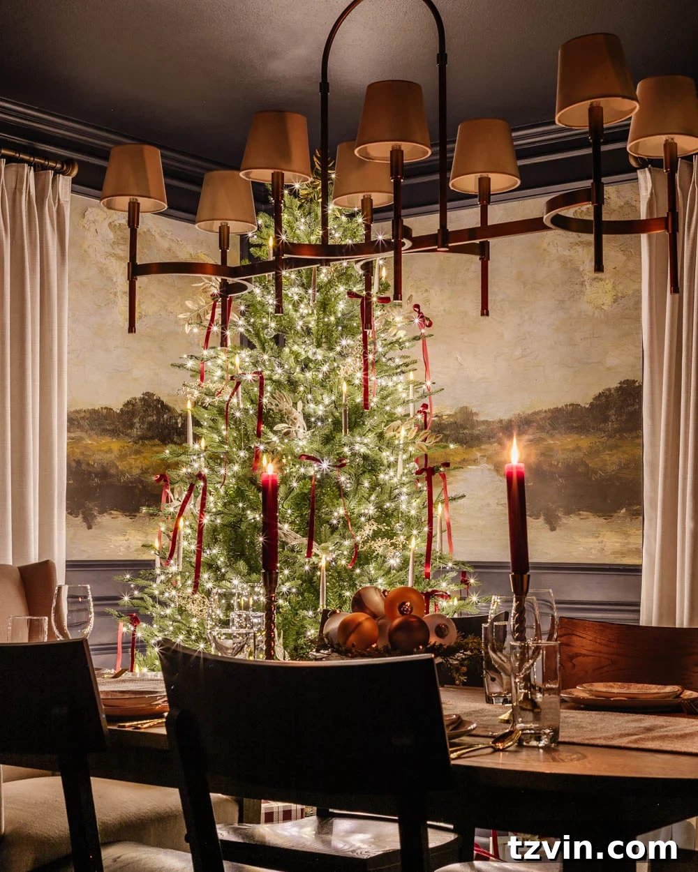 Dining room featuring a Christmas tree and a dining table with a candlelight centerpiece, creating a cozy holiday setting.