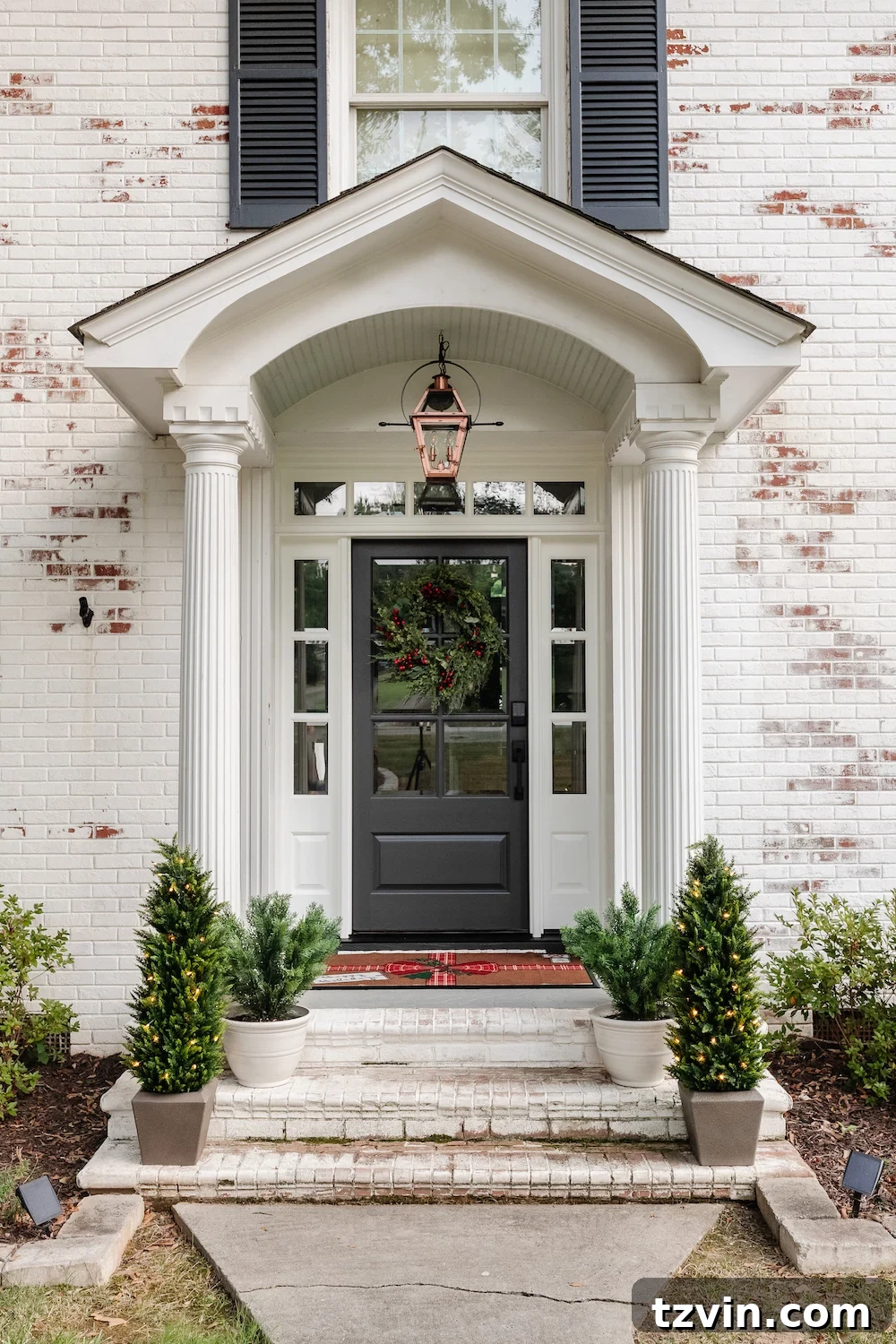 Welcoming colonial porch stoop adorned with a festive Christmas wreath and classic holiday decor, setting a traditional tone for our home tour.