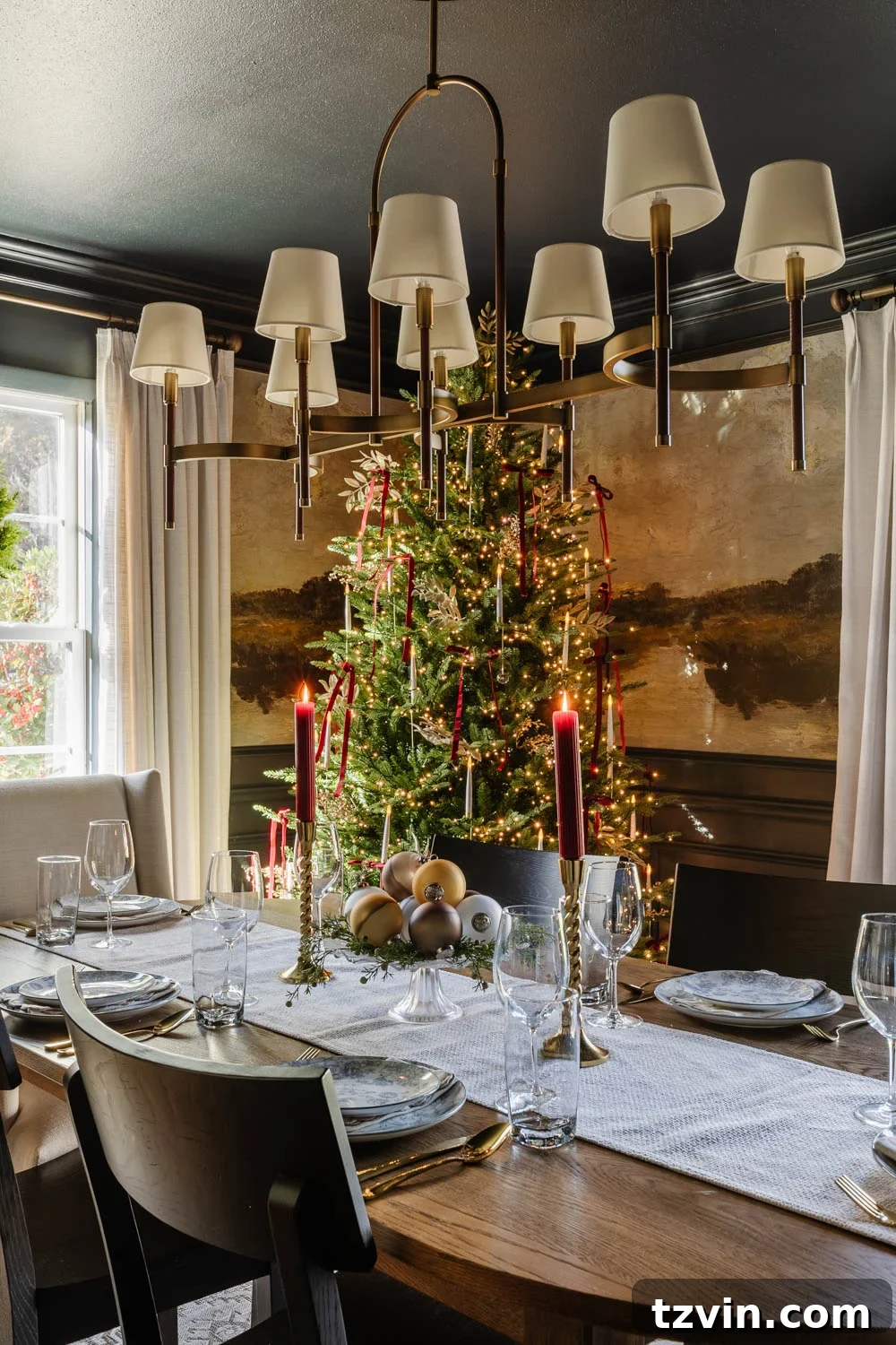 Close-up of a festive dining table setting in a modern colonial Christmas dining room, featuring holiday decor and an ornate chandelier.