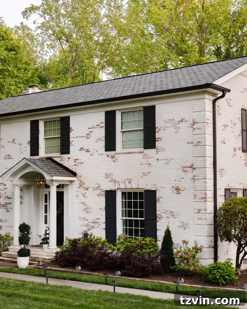 Wow-Worthy DIY Front Yard Transformations 11 Limewashed brick colonial house with new designer shingles roof and solar lights, showcasing complete curb appeal transformation