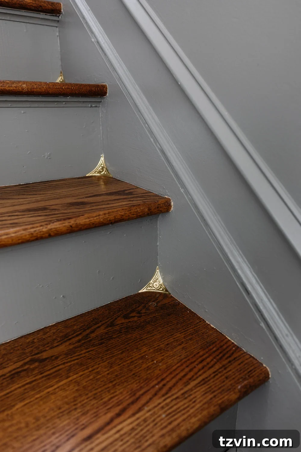 The Smart Way to Keep Your Stair Corners Dust-Free 4 Close-up view of antique brass stair dust corners installed on a wooden staircase