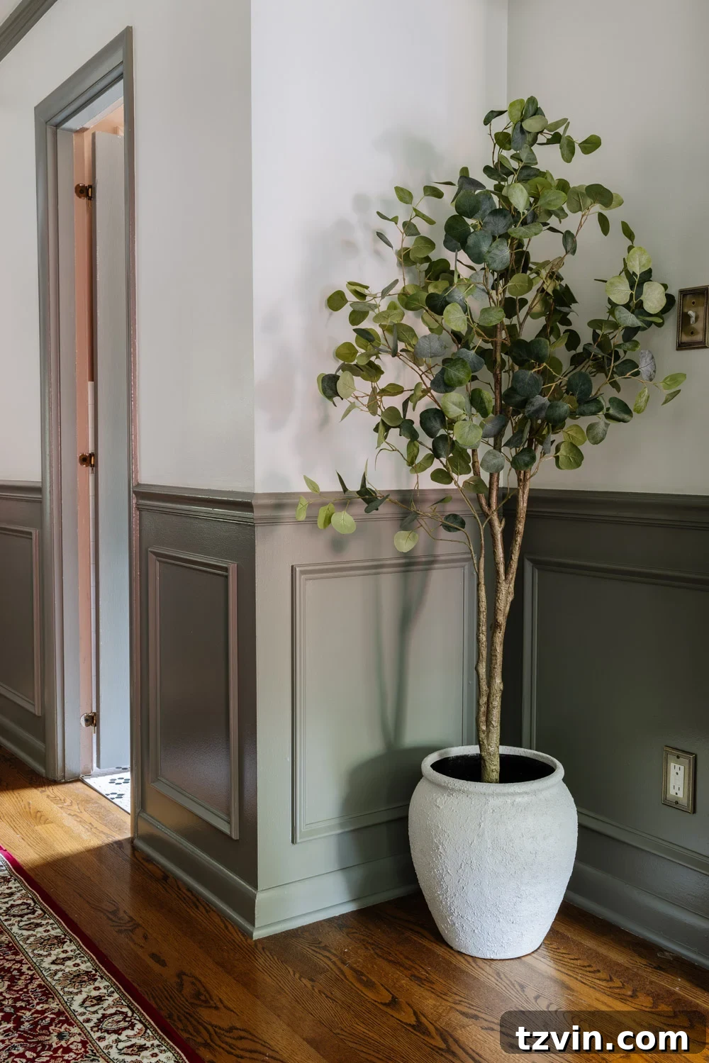 Design Hacks for Expansive Hallways 9 Small white ceramic planter on a thrifted piano stool in a hallway