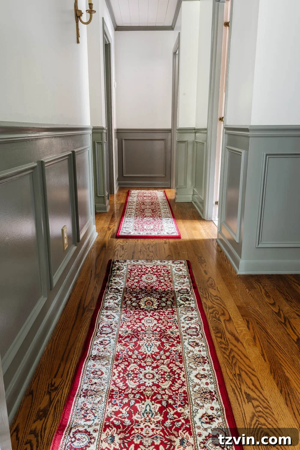Küçük Halıları Birleştirerek Büyük Halı Yapımı 2 Long hallway featuring a custom-made red vintage-style runner rug created by joining two shorter rugs, showcasing a seamless design