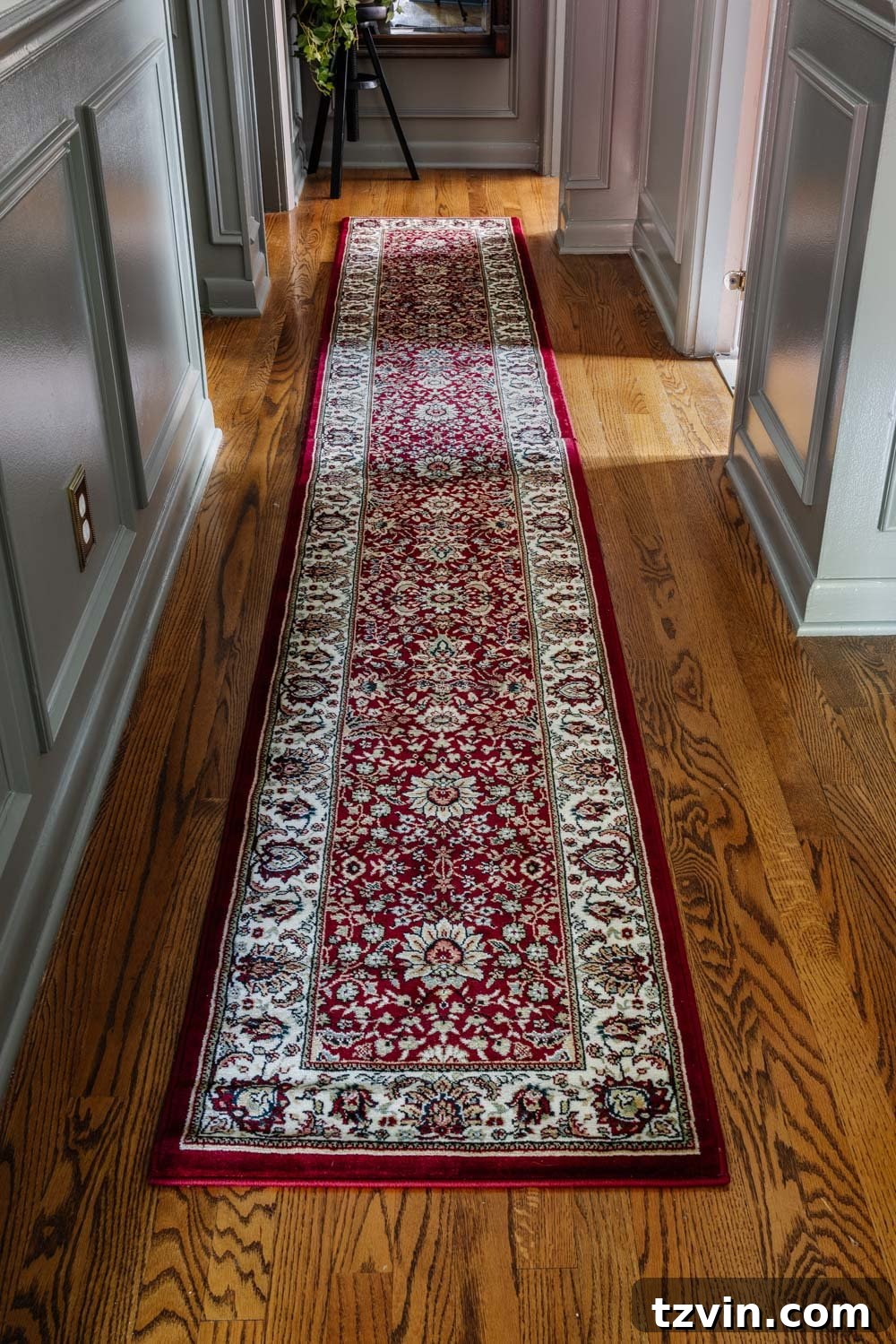 Küçük Halıları Birleştirerek Büyük Halı Yapımı 3 View of a beautifully decorated narrow hallway with a custom long red runner rug, demonstrating how two rugs were combined to fit the space perfectly