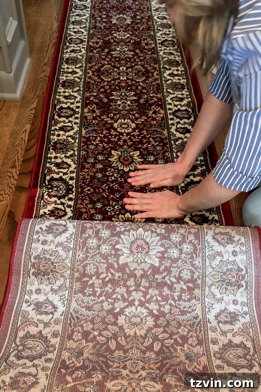 Küçük Halıları Birleştirerek Büyük Halı Yapımı 9 Hands pressing down the edge of a rug onto single-sided carpet tape on the floor, joining two rugs to create a custom runner