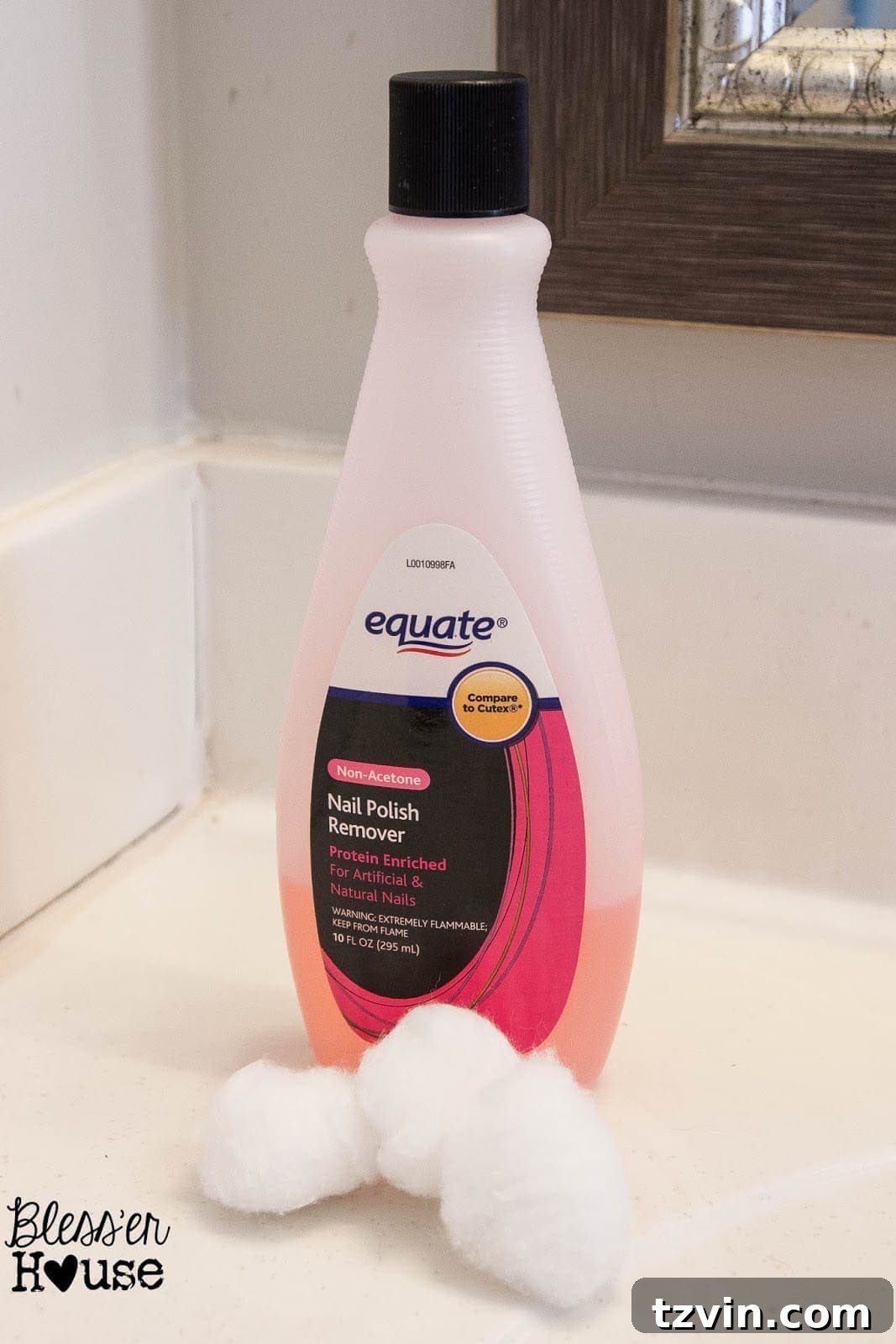 Nail polish remover bottle next to a cotton ball, demonstrating the overspray removal technique