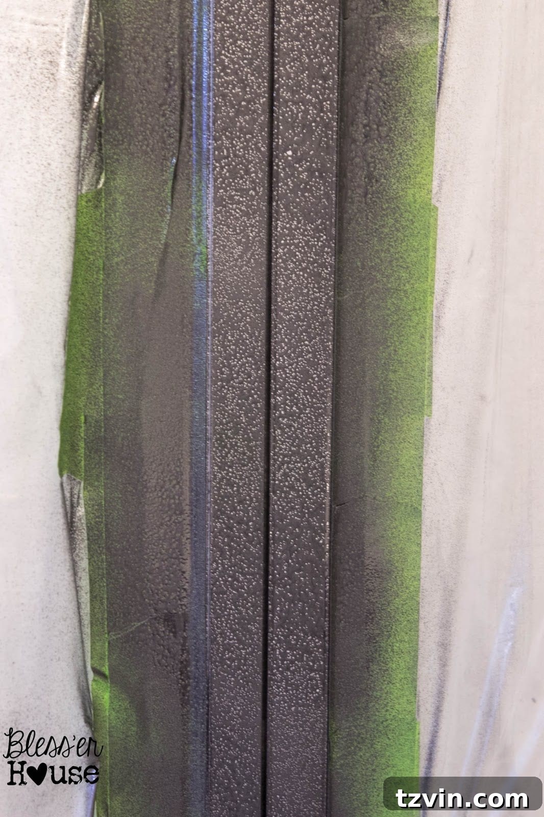 Close-up of a spray painted shower door frame after the first coat, showing potential imperfections