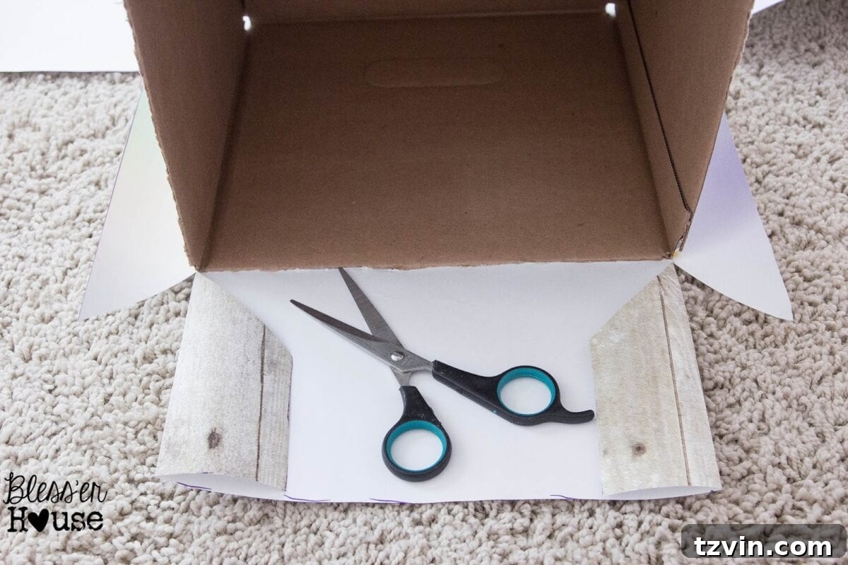 Craft paper being cut diagonally at the top corner of the box for a clean fold to the inside.