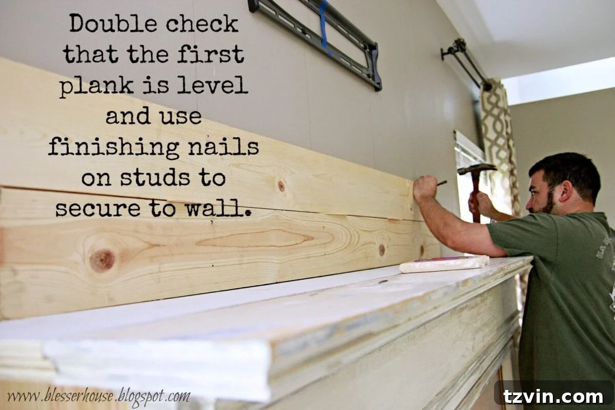 First 1x6 pine planks being installed on the wall, secured with finishing nails into studs for a sturdy foundation.