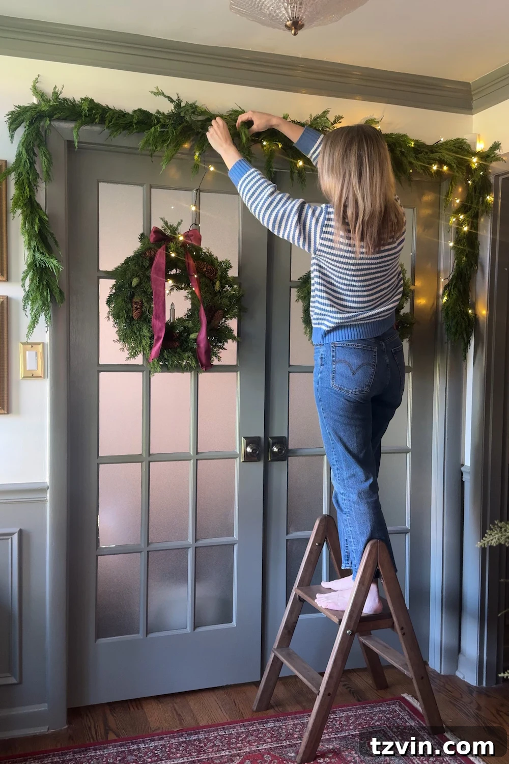 Illuminated Christmas doorway garland with warm string lights