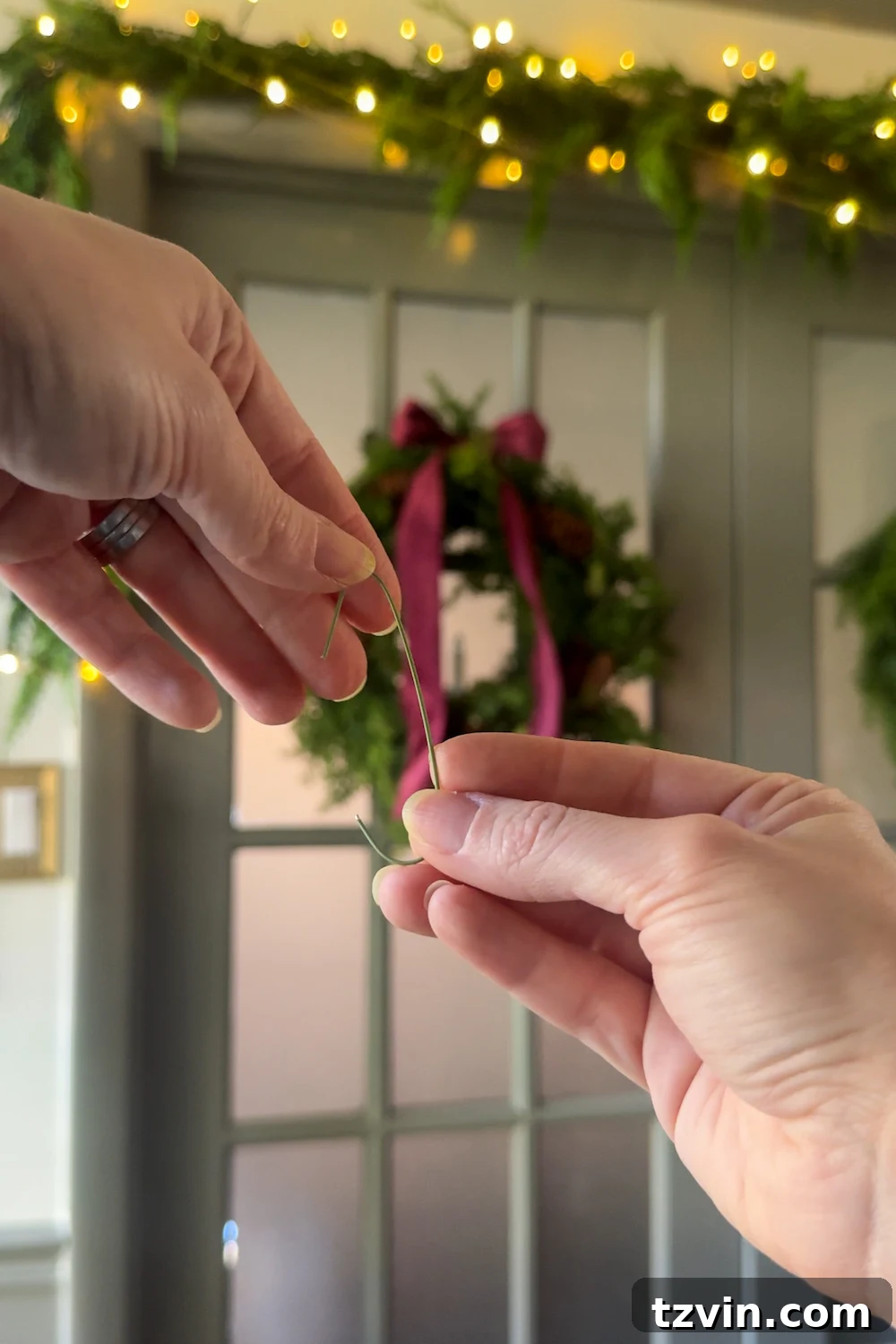 Adding embellishments to the doorway garland: faux flowers and berries