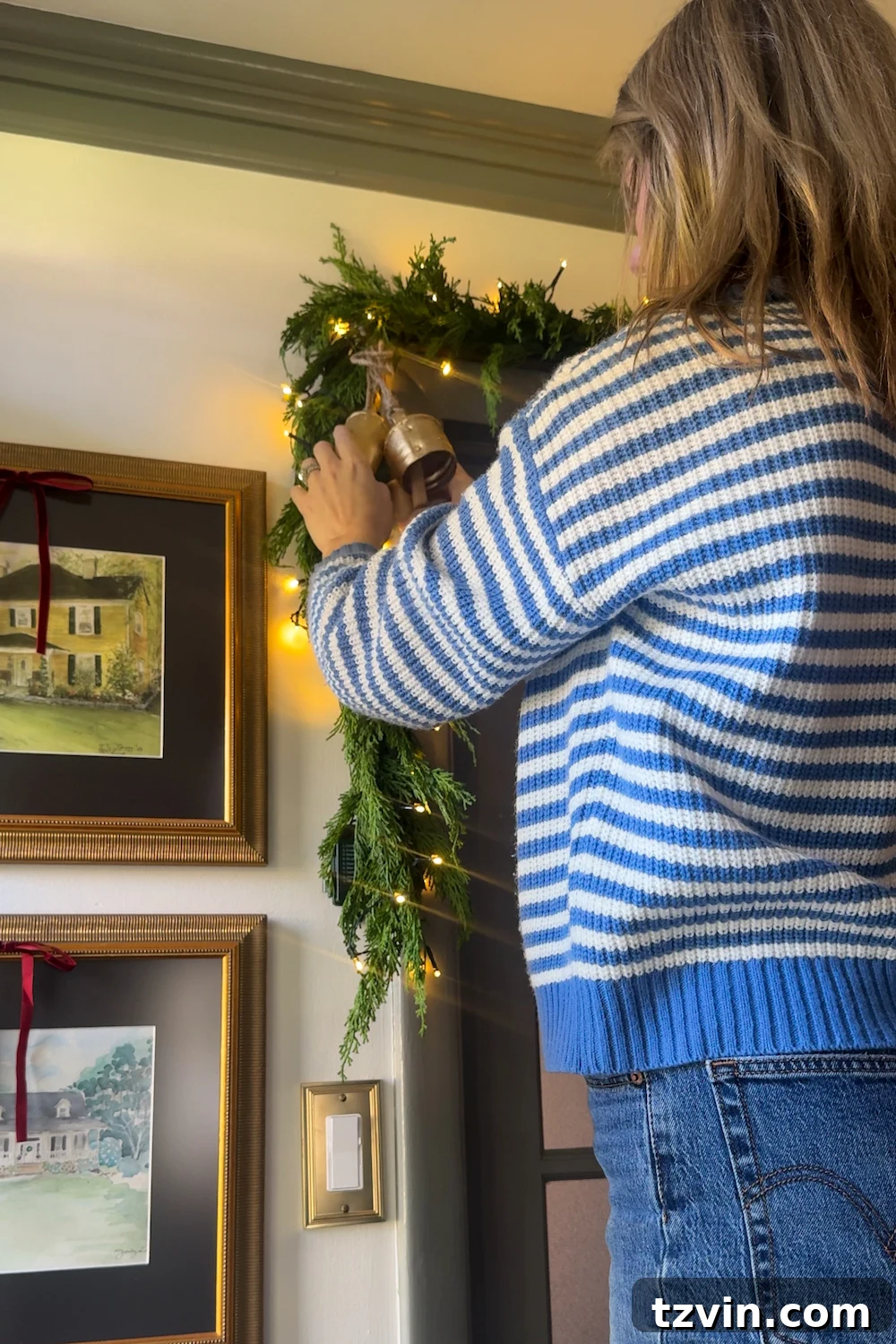 Finished Christmas doorway garland with a mix of embellishments and warm lighting