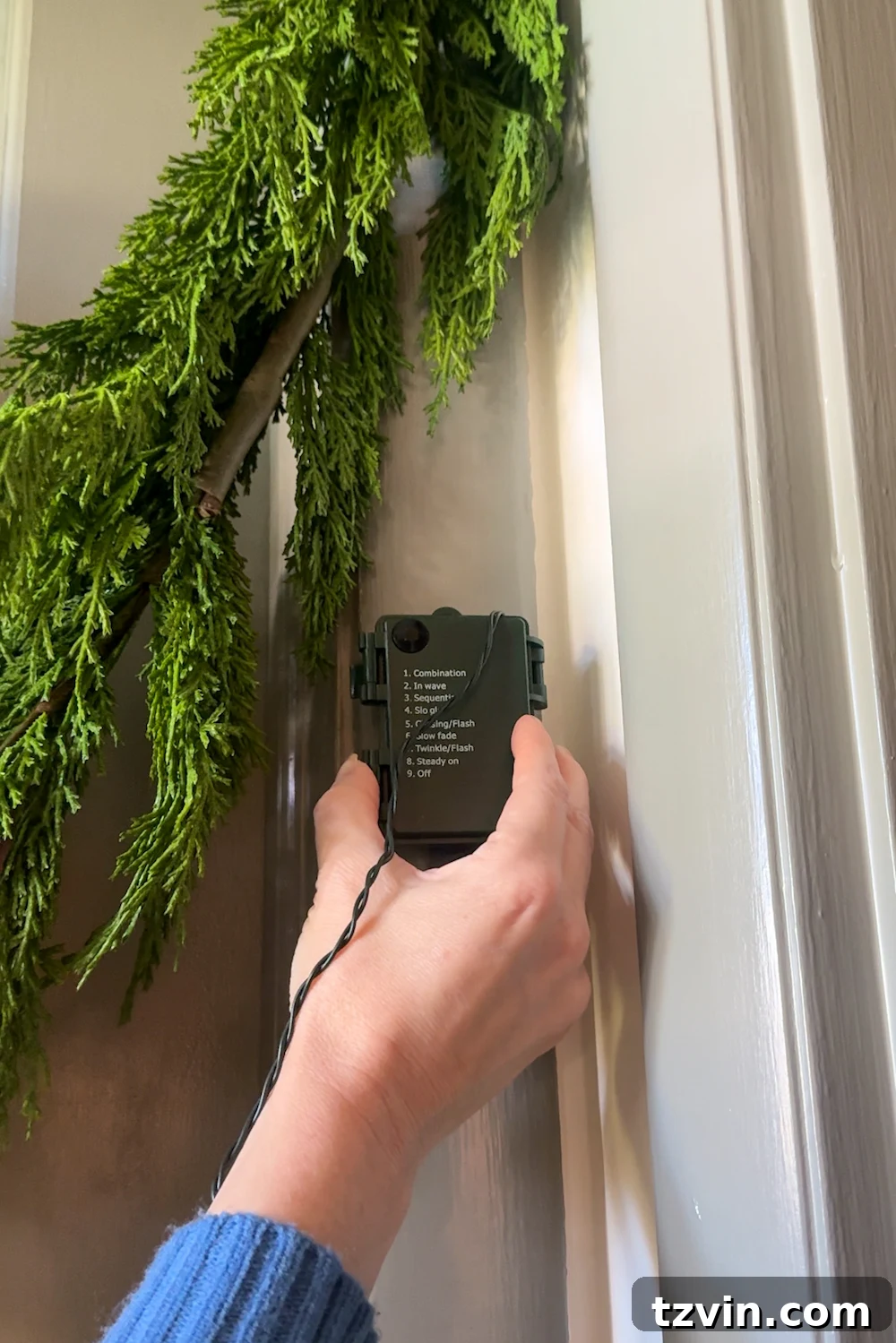 Securing the battery pack of the string lights behind the garland