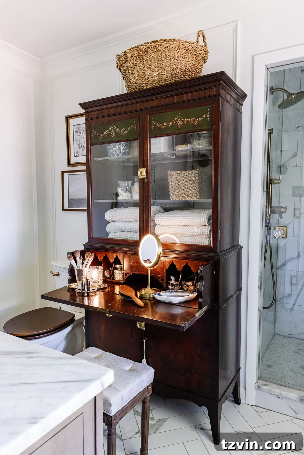 Repurposing a Secretary Desk: A DIY Makeup Vanity for Our Small Bathroom 3 Closed secretary desk serving as a stylish makeup vanity in a bathroom, showcasing its compact design and elegant appearance, complete with a small stool tucked underneath.