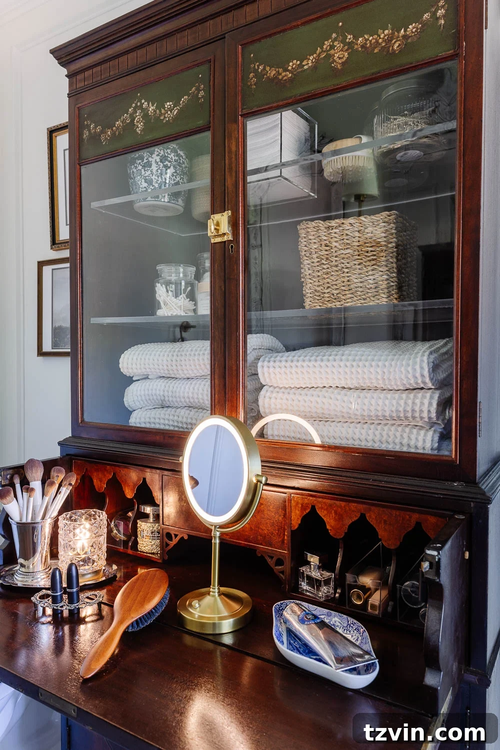 Repurposing a Secretary Desk: A DIY Makeup Vanity for Our Small Bathroom 4 Open secretary desk revealing organized makeup vanity with mirror, brushes, and small lamp, demonstrating hidden storage potential in a bathroom setting.