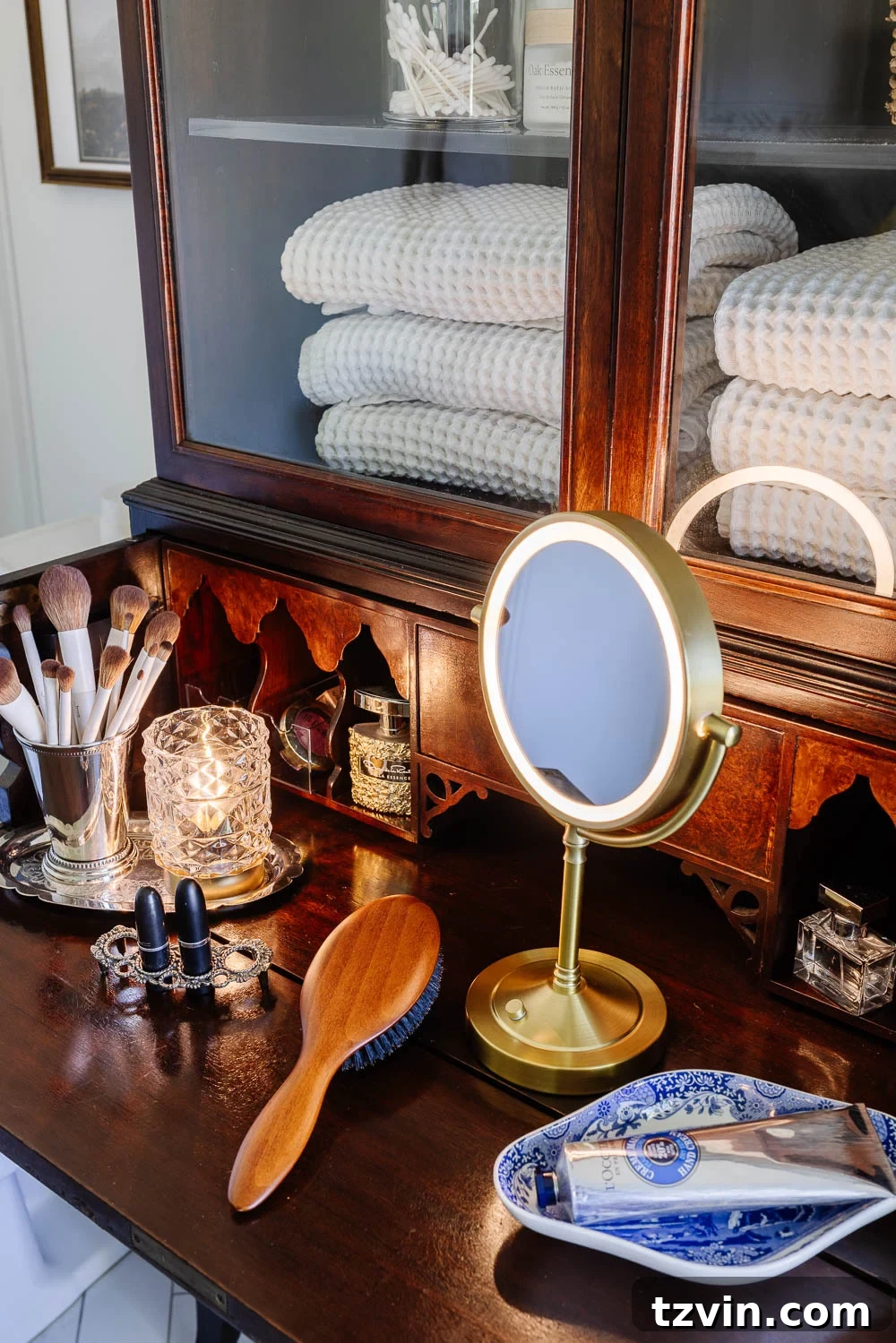 Repurposing a Secretary Desk: A DIY Makeup Vanity for Our Small Bathroom 7 Close-up of neatly arranged apothecary jars within the top cabinet of a secretary desk makeup vanity, holding cotton balls and Q-tips, enhancing organized bathroom storage.